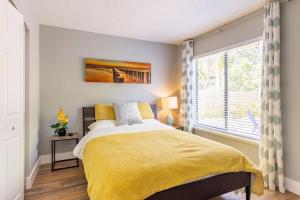 - une chambre avec un lit doté d'une couverture jaune et d'une fenêtre dans l'établissement Charming townhome w/ private backyard & fire pit, à Palm Beach Gardens