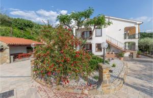 una casa con un arbusto con flores rojas delante en Lovely Apartment In Secovlje With House Sea View en Sečovlje