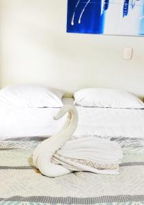 a white snake laying on top of a bed at POUSADA EVELINA in Foz do Iguaçu