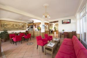 a living room with a couch and red chairs at Hotel Stanger in Lovran