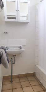 a white bathroom with a sink and a mirror at Burdekin Motor Inn in Home Hill +9 photos