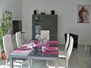 a dining room table with pink plates and wine glasses at Gîte de charme en Touraine avec clim, jardin et toutes commodités incluses, proche Châteaux de la Loire - FR-1-381-102 in Veigné +13 photos