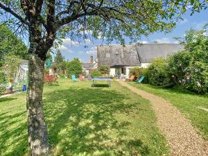 a yard with a tree and a house at Gîte de charme en Touraine avec clim, jardin et toutes commodités incluses, proche Châteaux de la Loire - FR-1-381-102 in Veigné