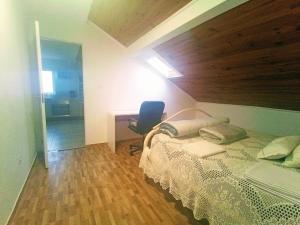 een slaapkamer met een bed, een bureau en een stoel bij Ginjals_67 in Almargem