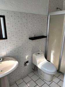 ein weißes Bad mit einem WC und einem Waschbecken in der Unterkunft Casa Lili in Cuernavaca
