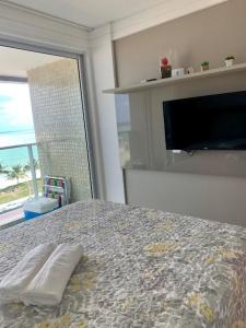 a bedroom with a bed with a television and a window at Flat maravilhosa vista beira mar de Intermares 605 in Cabedelo