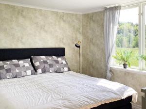 a bed in a bedroom with a large window at Holiday home FÄRGELANDA VI in Färgelanda