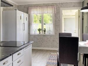 a kitchen with a white refrigerator and a table at Holiday home FÄRGELANDA VI in Färgelanda