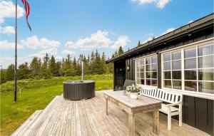 una terraza de madera con banco y bañera de hidromasaje en 3 Bedroom Amazing Home In Lillehammer en Lillehammer