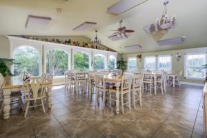 a dining room with tables and chairs and windows at Southern Cross Guest Ranch in Madison