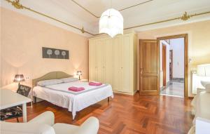 Stunning Home In Palazzolo Acreide With Kitchen في بالاتسولو أكريدي: غرفة نوم مع سرير مع وسائد وردية عليه