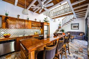 a kitchen with a large wooden counter top and chairs at Casa Tequila in Santa Cruz