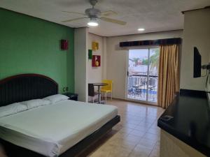 a bedroom with a white bed and a green wall at Suites Los Arcos in Isla Mujeres