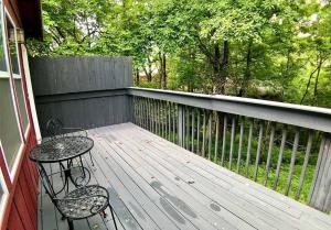 een houten terras met een tafel en een stoel erop bij Oak Crest – Mountain Chalet/#9 in Eureka Springs