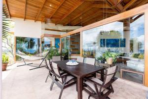 comedor con mesa de madera y sillas en Villa Dos Playas, en Playa Hermosa