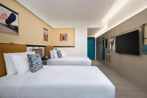 西安的住宿－西安Moxy酒店，酒店客房设有两张床和一台平面电视。