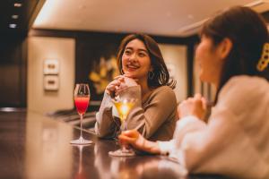 Dos mujeres sentadas en un bar con copas de vino en Kyoto Century Hotel, en Kioto