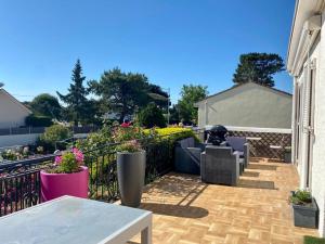 a patio with chairs and tables and a fence at Chambre cosy RDC avec véranda, jardin privé et wifi, proche plage – Saint-Michel-Chef-Chef - FR-1-306-1256 in Saint-Michel-Chef-Chef
