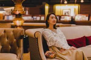 a woman sitting on a couch in a room at Kyoto Century Hotel in Kyoto