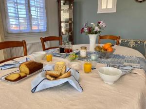 a table with bread and orange juice on it at Chambre cosy RDC avec véranda, jardin privé et wifi, proche plage – Saint-Michel-Chef-Chef - FR-1-306-1256 in Saint-Michel-Chef-Chef +10 photos