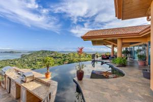 an outdoor patio with a pool and a view of the water at Casa de Grandes Vistas in Playa Hermosa