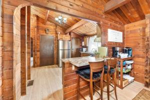 een keuken met houten wanden en een bar met barkrukken bij Cozy Copper Cabin in the City in Sioux Falls