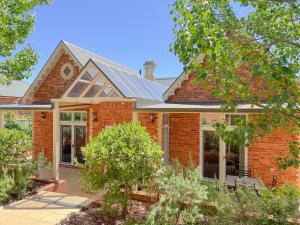 a red brick house with a solar roof at The Monarch Tumut - Luxury in the valley in Tumut