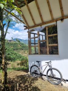 佩雷拉的住宿－Cabaña el Ensueño (GUADUA, BAMBU)，停在大楼旁的一辆自行车,享有美景
