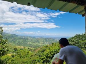 człowiek stojący na szczycie wzgórza patrzący na dolinę w obiekcie Cabaña el Ensueño (GUADUA, BAMBU) w mieście Pereira