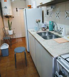 a kitchen with a sink and a refrigerator at Departamento Céntrico Ciudad Mendoza Belgrano y Aristides con cochera in Mendoza +3 photos