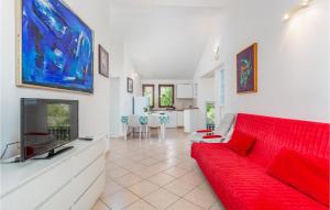 a living room with a red couch and a tv at Awesome Apartment In Pinezici With Wifi in Pinezici