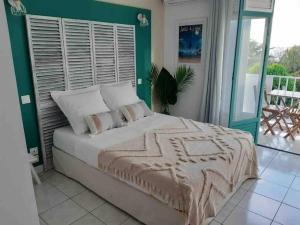 - une chambre dotée d'un lit avec un mur vert dans l'établissement La Perle Iléenne, vue imprenable sur la mer., à Les Trois-Îlets
