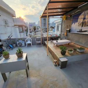 eine Dachterrasse mit Topfpflanzen auf einem Gebäude in der Unterkunft JUN house - Foreign Only in Busan