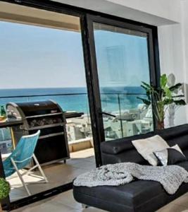 a living room with a couch and a view of the ocean at Bat Yam Luxery 5BR Sea View Suite in Bat Yam