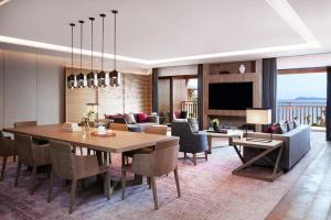 a dining room and living room with a table and chairs at Shenzhen Marriott Hotel Golden Bay in Shenzhen