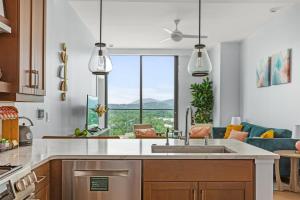 a kitchen with a sink and a living room at 'Mountain Gem' A Luxury Downtown Condo with Mountain and City Views at Arras Vacation Rentals in Asheville