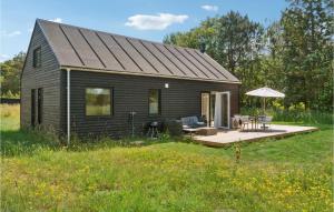 a small house with a deck and a patio at Nice Home In Sams With Kitchen in Nordby