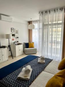 um quarto com uma cama grande e toalhas em SUNSTUDIO TARIK AL em Portimão