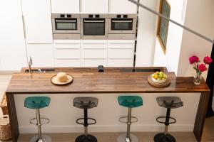 a kitchen with a counter with stools around it at The Studio in Pevensey