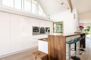 a kitchen with white cabinets and a counter with a sink at The Studio in Pevensey