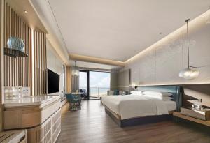 Qinhuangdao Marriott Resort في تشنهوانغداو: غرفه فندقيه سرير وتلفزيون