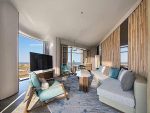 a living room with a couch and a tv at Qinhuangdao Marriott Resort in Qinhuangdao