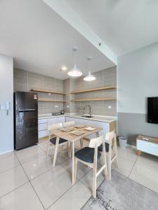 a kitchen with a table and chairs and a refrigerator at Sunway onsen suite ipoh in Ipoh