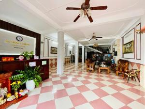 a living room with a ceiling fan and a checkered floor at Nhà nghỉ Xuân Long - Xuan Long gues - Tỉnh Điện Biên in Ban Hin Lom