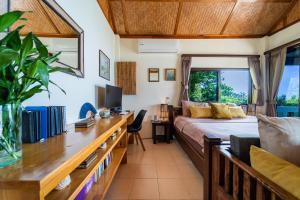 1 dormitorio con 1 cama y escritorio con ordenador en White Azure Villa Two, en Than Sadet Beach