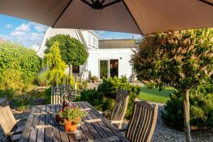 a wooden table and chairs with an umbrella at The Studio in Pevensey +42 photos