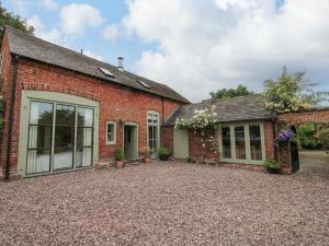 een oud bakstenen gebouw met een binnenplaats ervoor bij Old Coach House in Shrawardine