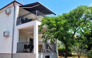 biały dom z balkonem i drzewem w obiekcie Apartment Korni - comfortable w Biogradzie na Moru