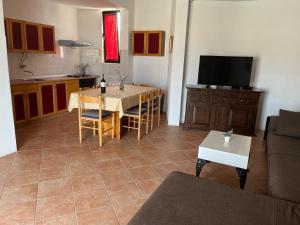 a kitchen and living room with a table and a television at Apartment Željka-25m from beach in Zaglavice