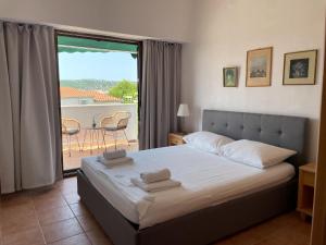 a bedroom with a bed and a view of a patio at Apartment Željka-25m from beach in Zaglavice